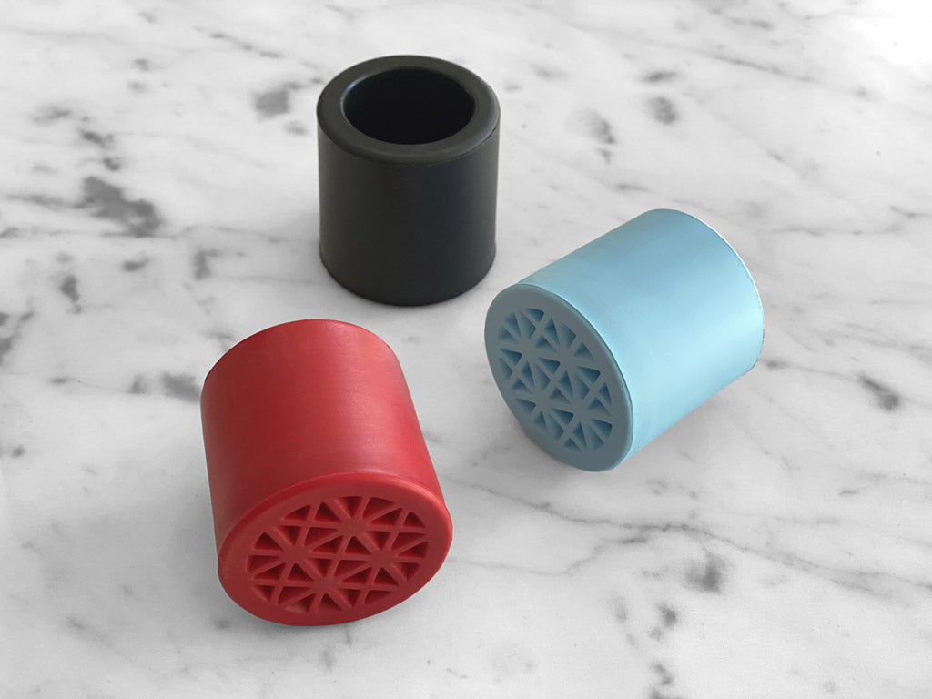 red blue and black rubber walking stick tips on marble background