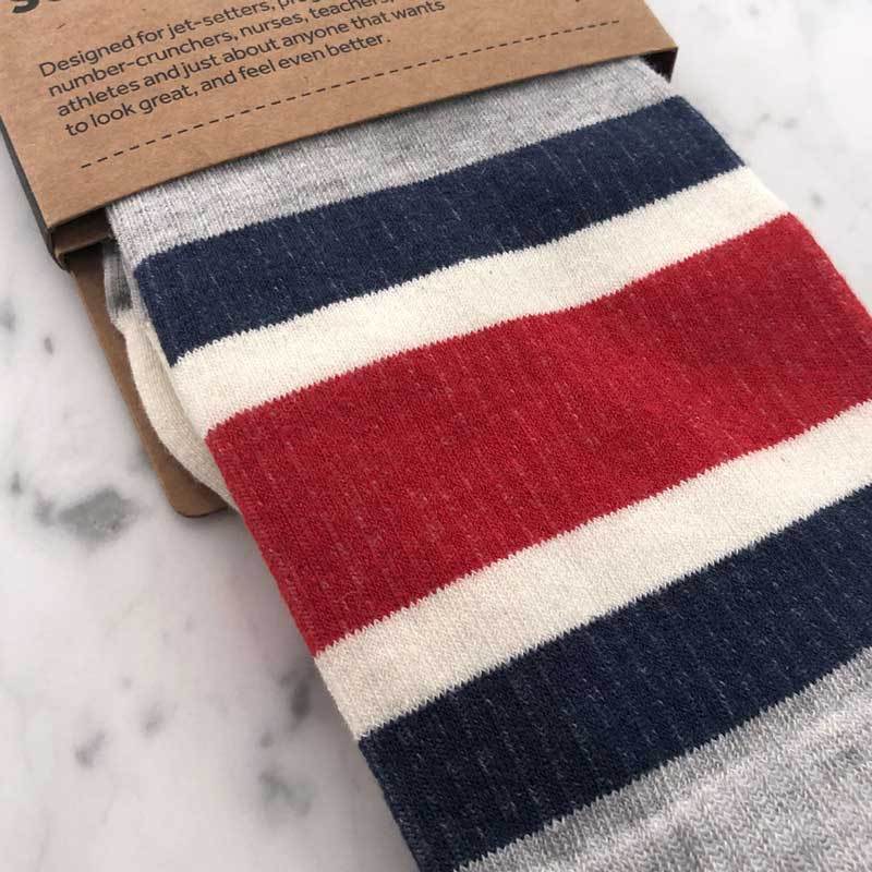Close detail of sport stripe pattern compression socks in heather grey, blue and red